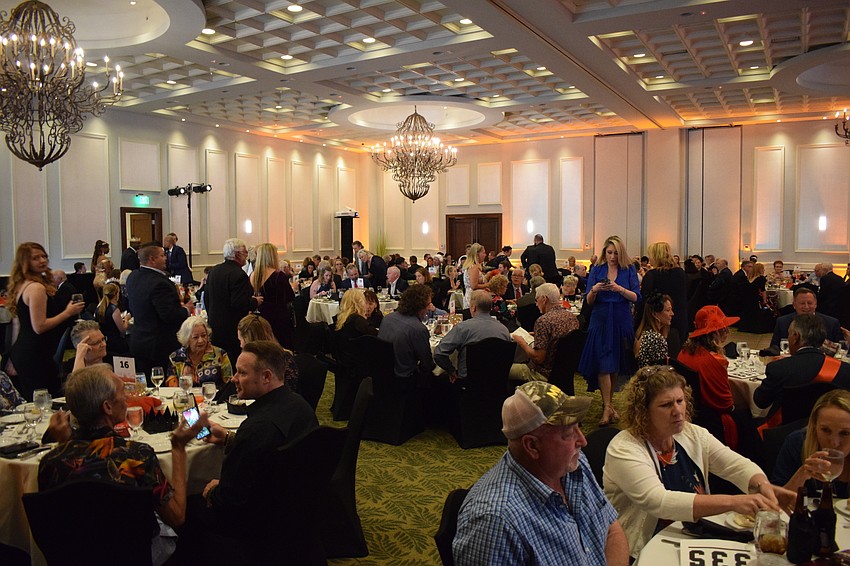 The ballroom is filled with people dressed as British royalty.