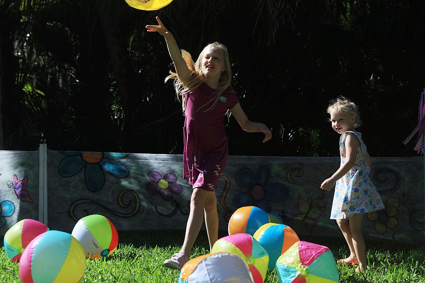 Melissa and Evelyn Mensley play with beach balls.