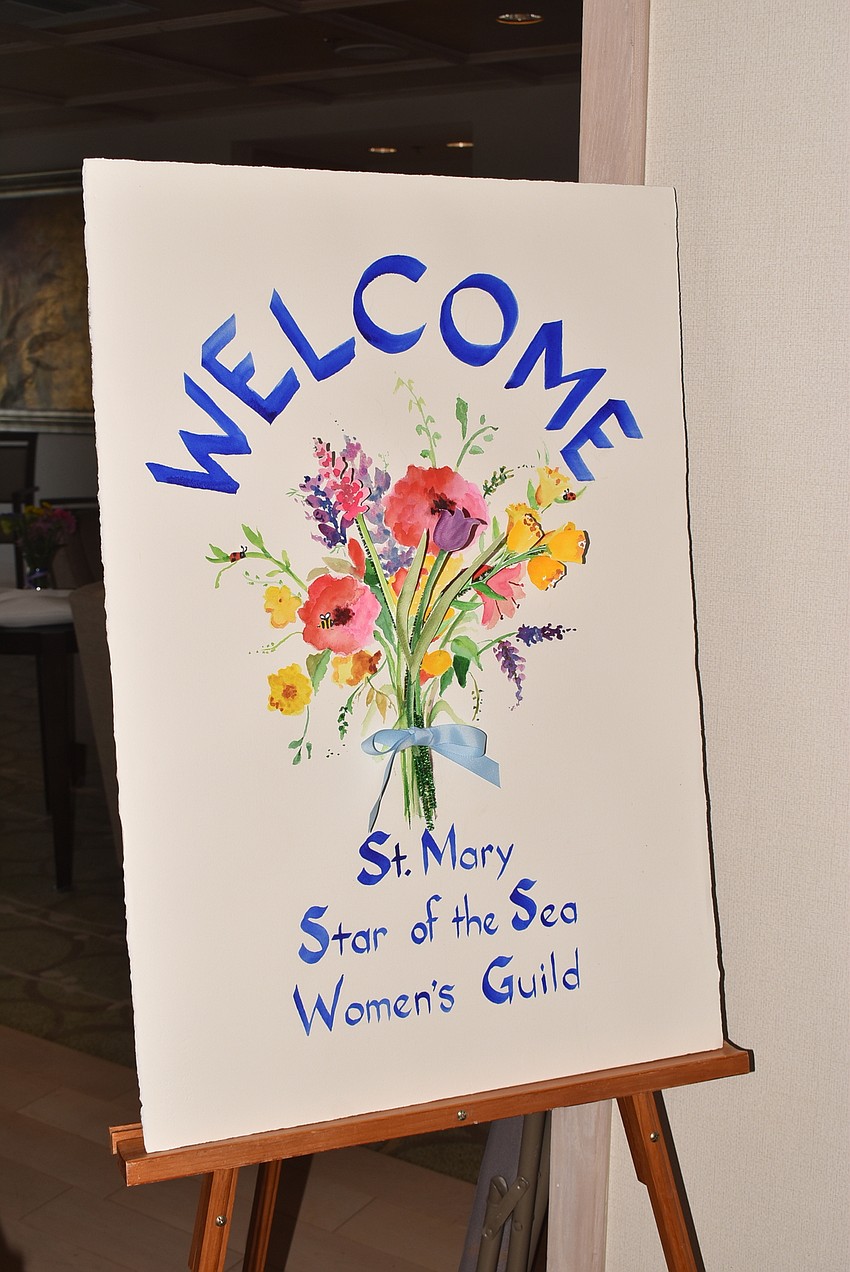 A colorful sign welcomed new members to the luncheon.