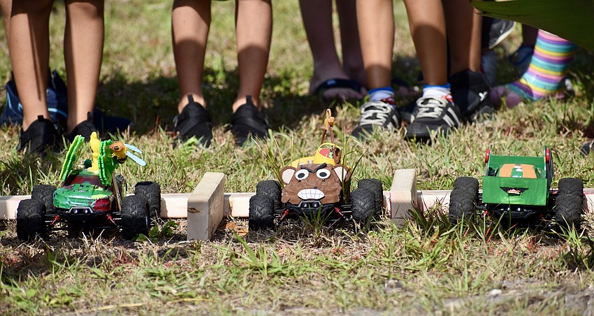A trio of cars lines up for an elementary-school division race.