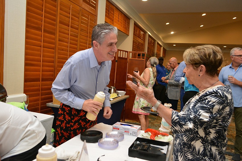 Lazy Lobster owner Michael Garey serves up a dish to Carol Peschel