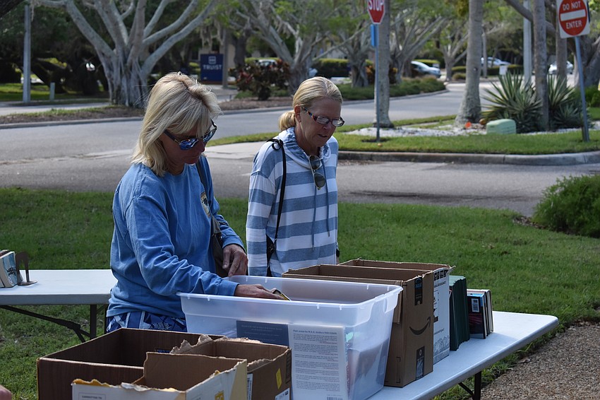 Beth Fortune, left, and Debbie Turner look through some of the Longboat Library's for-sale offerings.