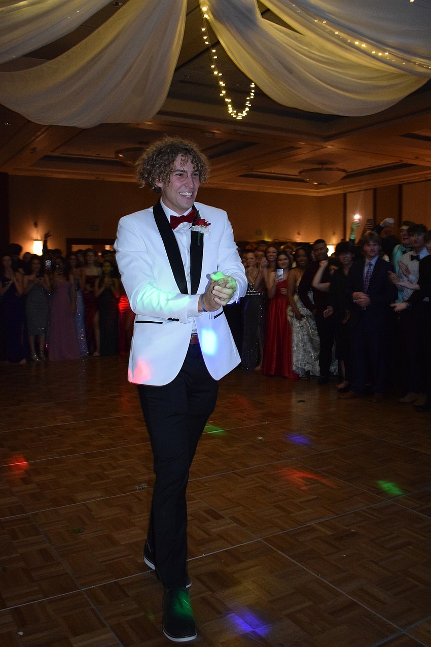 Senior Tobin Santilli walks forward to get his crown after being named prom king.