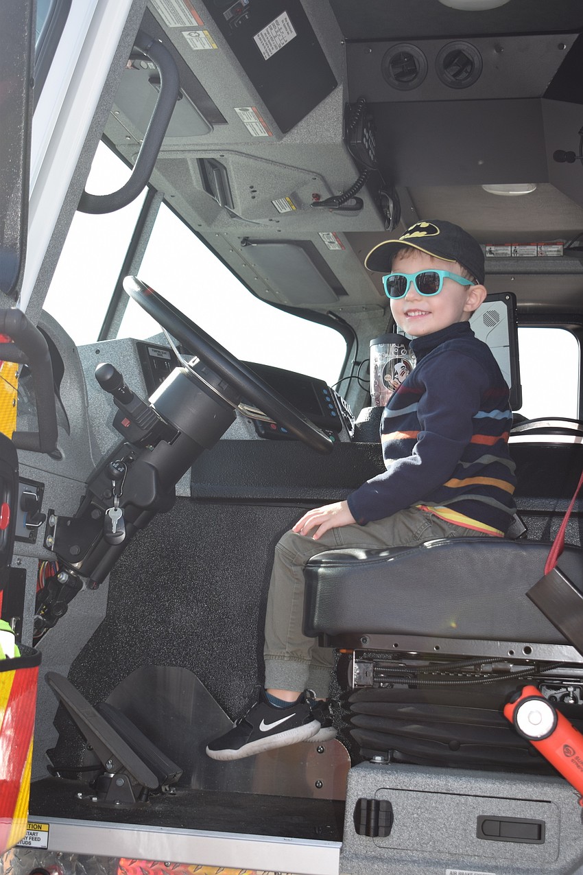 Greenbrook's Emmett O'Brien, who is 4 years old, enjoys sitting in the driver's seat of a Sarasota County firetruck.