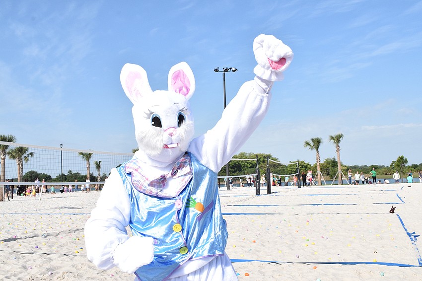 The Easter Bunny dances and waves to families before the egg hunt begins.
