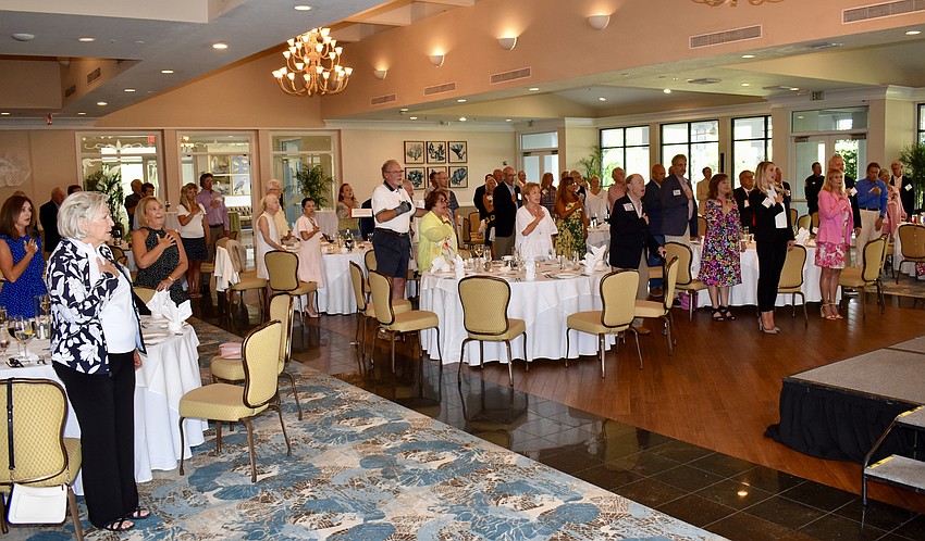 Guests say the Pledge of Allegiance before the program begins.