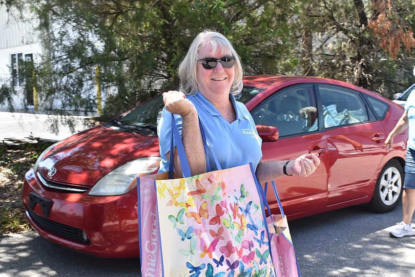 Carol Erker organizes the perishable groceries in the shade.