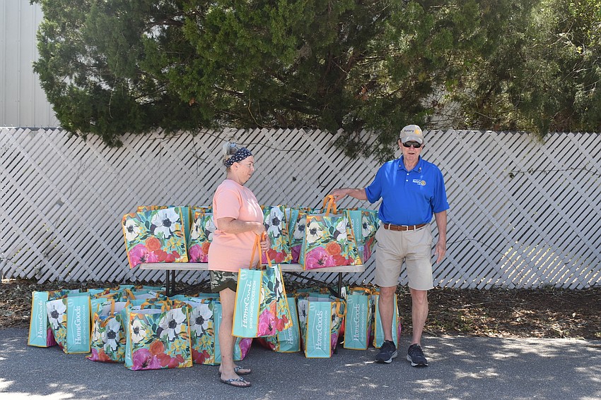 Kelly Taylor gets ready to drop off bags as Jack Rozance organizes the tables.