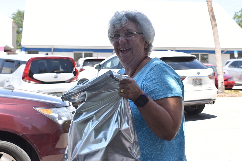 Susan Veshosky carries bags to a car.
