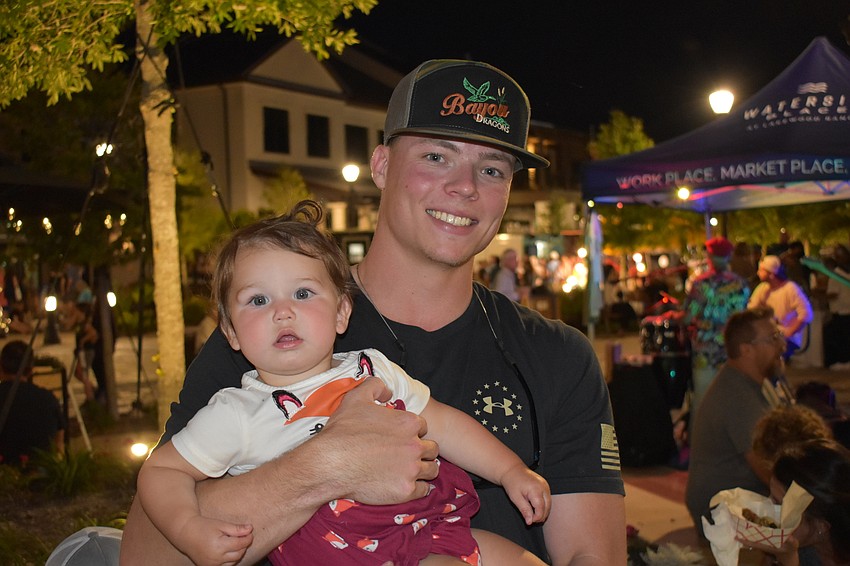 Waterside's Ethan Hale holds 1-year-old Evie Fordyce while visiting Waterside Place with his friend who is Evie's mom, Brandy Fordyce. The two friends come out every week and said Evie Fordyce also loves the event and the music.