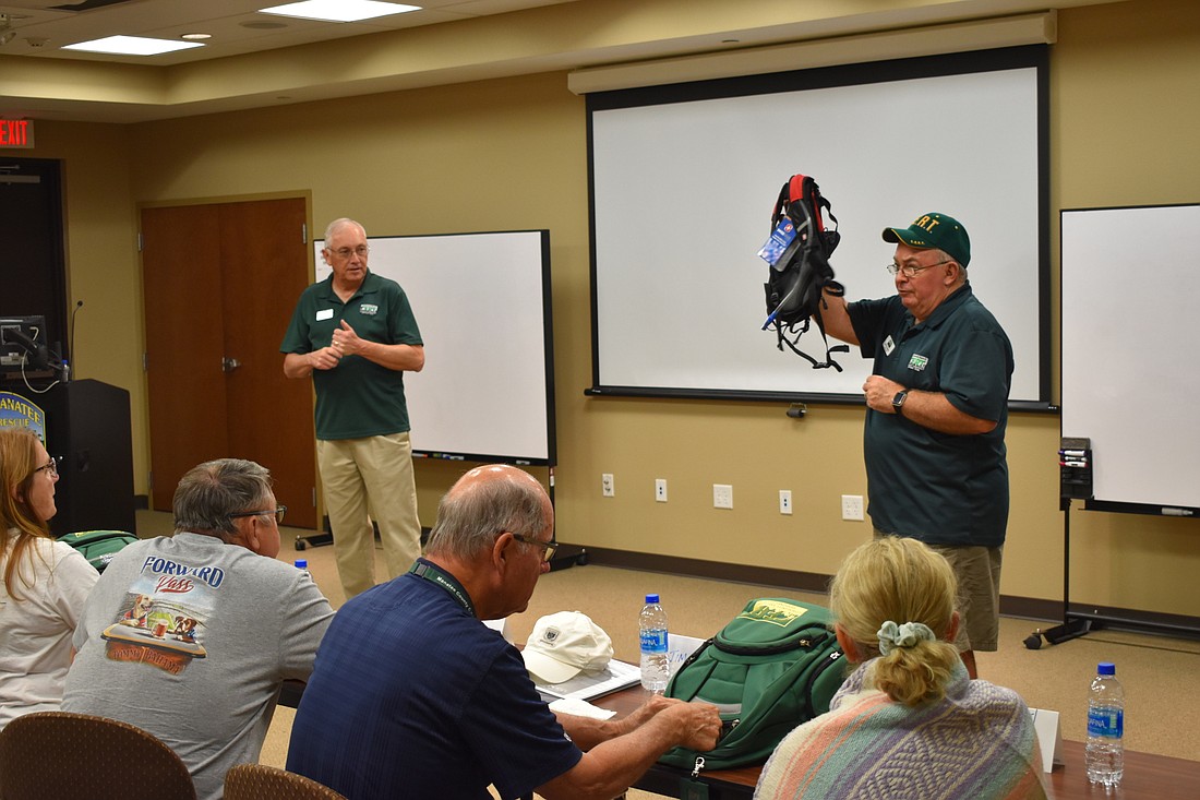 Instructor Pat Knowles (right) demonstrates the features of the CERT backpack.
