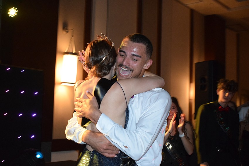 Senior David Kochaniec hugs senior Jacsyn Hockenbury after they are named prom king and queen.