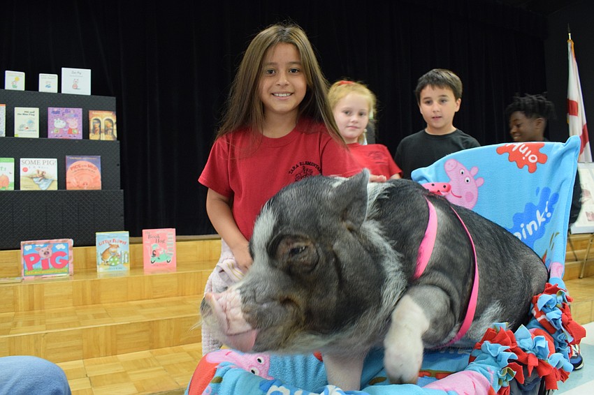 Second grader Miranda Puldo pets Daisy as second graders Olivia Jones and Michael Samson wait their turn.