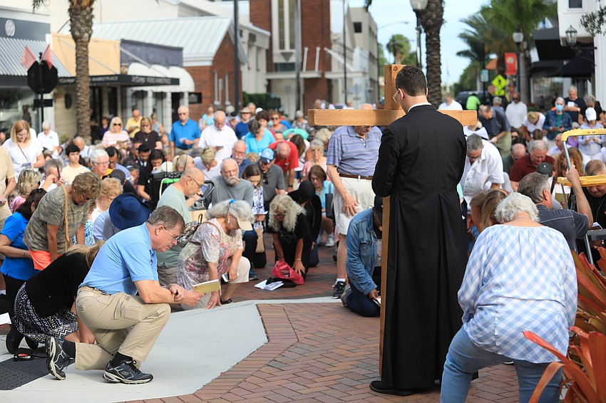 The crowd kneels at one of the stations.