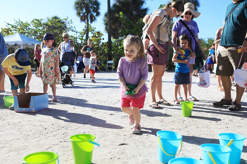 Natalie Van Ryzin drops a bean bag into a bucket.