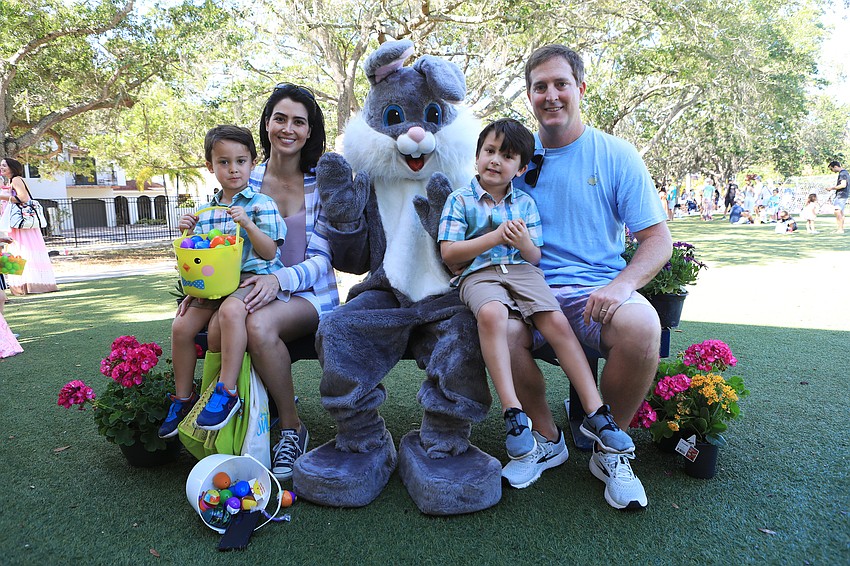 Alex, Alicia, Robert Brown and Robert Brown take photos with the Easter Bunny.