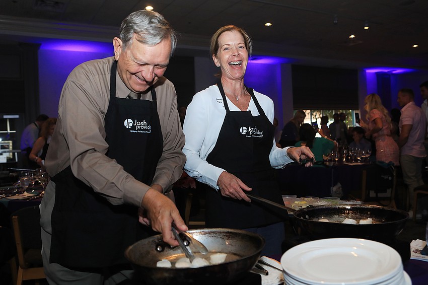 Bob Lewandowski and Jennifer Vigner prepare for their table.