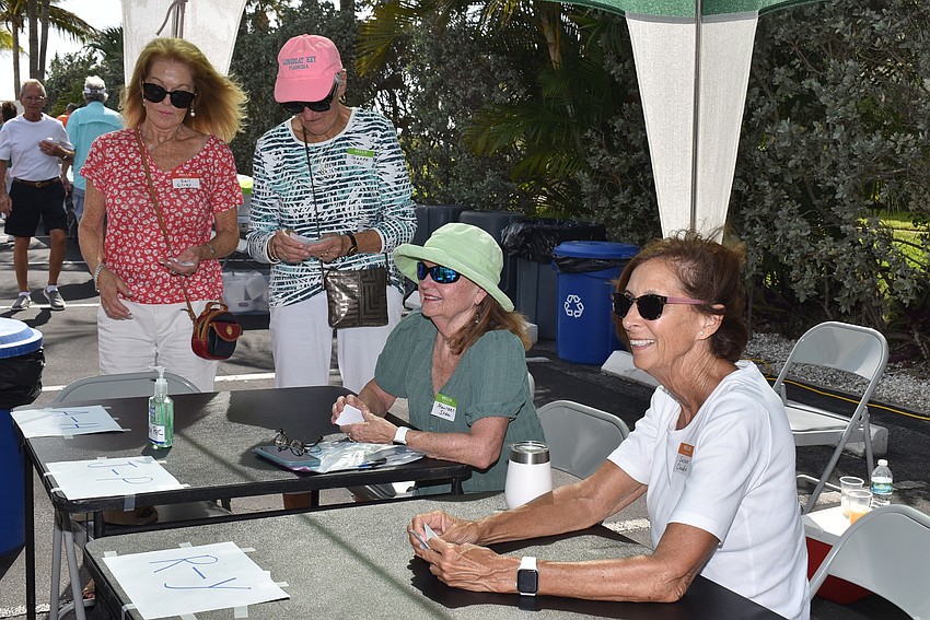 Susan Claudio, right, checks attendees in.