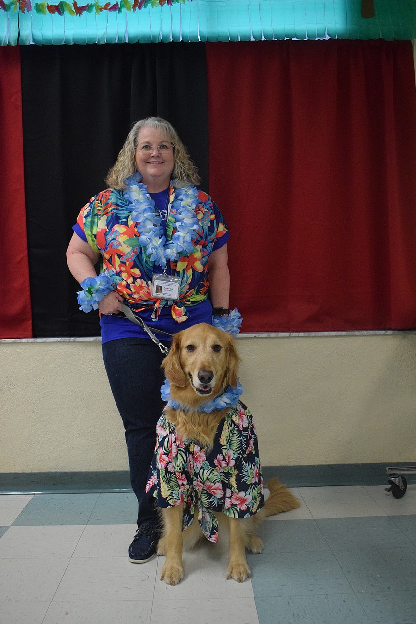 Assistant Principal Karen Chinault gets into the spirit of the luau by dressing in a Hawaiian shirt with Callie, the school's therapy dog. Students were thrilled to see Callie at the spring dance.
