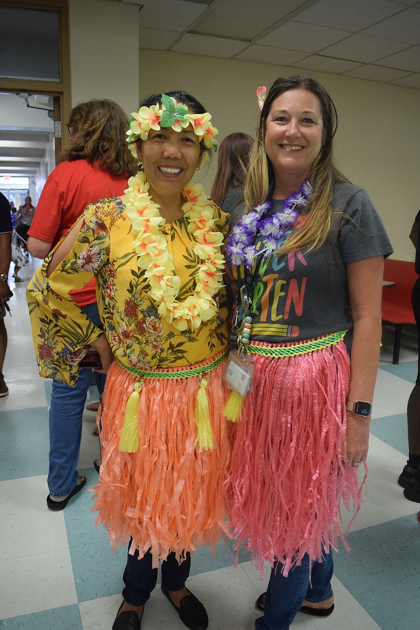 Kindergarten teachers Josephine Johnson and Kelly Walker are ready to lead students in a Hawaiian dance.