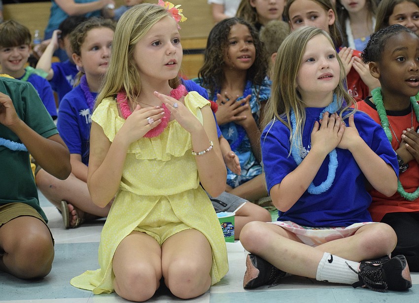First graders Olivia Kumpf and Piper Miles follow along in the Hawaiian dance. 