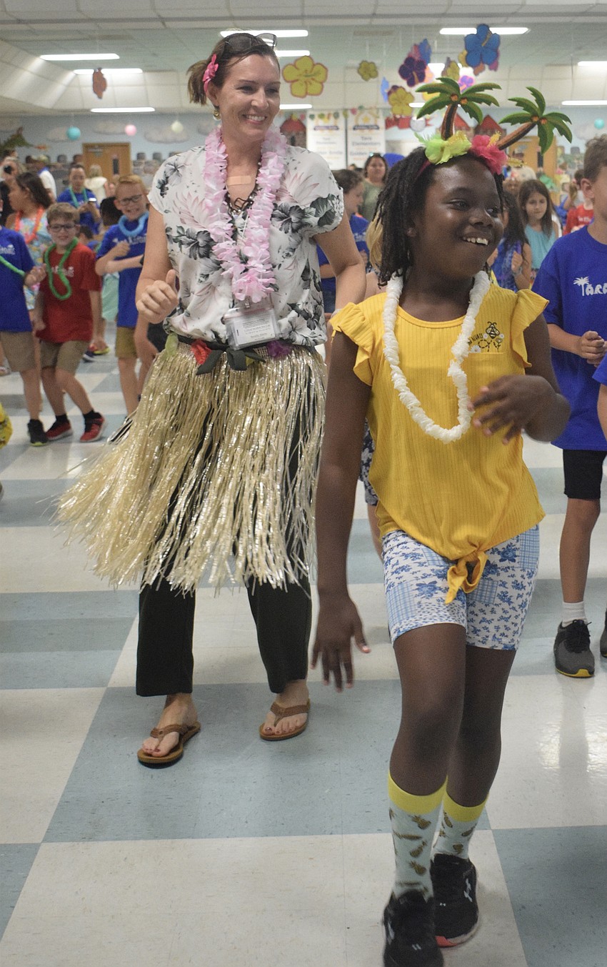 Principal Laura Campbell and fourth grader Kaylani Roney dance to the 