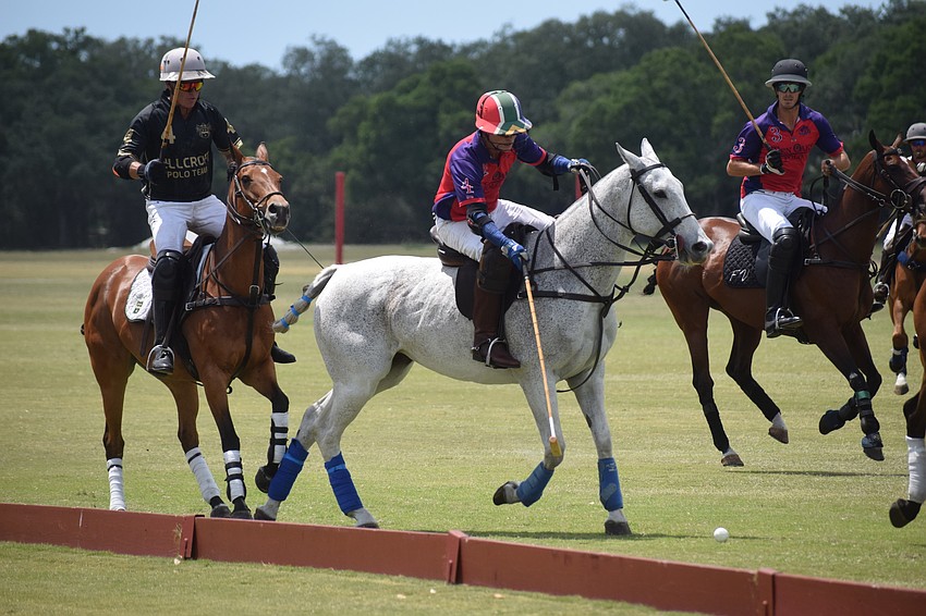Regent's Stuart Campbell, center, clears the ball away from the board on the sideline.