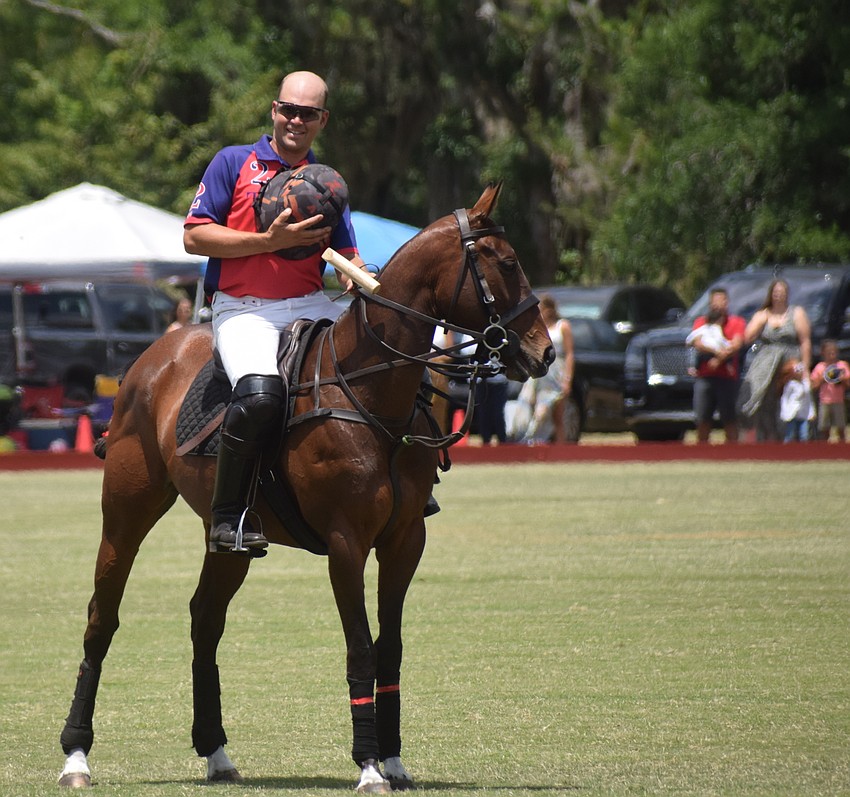 Regent's Neil Osburg honors the flag during the Star Spangled Banner.