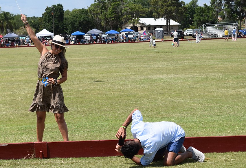 Bradenton's Clara Rubio flies a kite at the Sarasota Polo Club as Juan Baquero tries to get the right angle. Flying kites was a fundraiser for the Children's Cancer Center of Tampa.