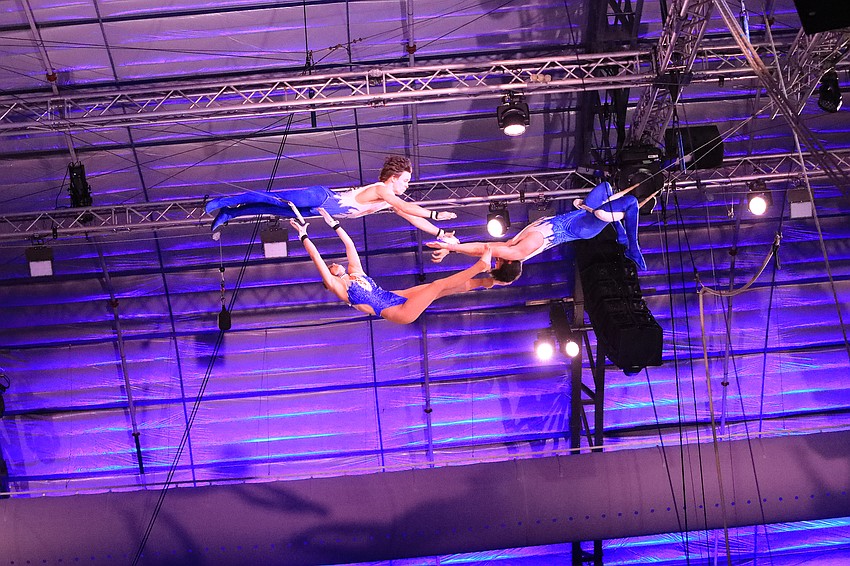 Channing and Caleb Gross pass from swing to swing with Kaylee Dutkiewicz