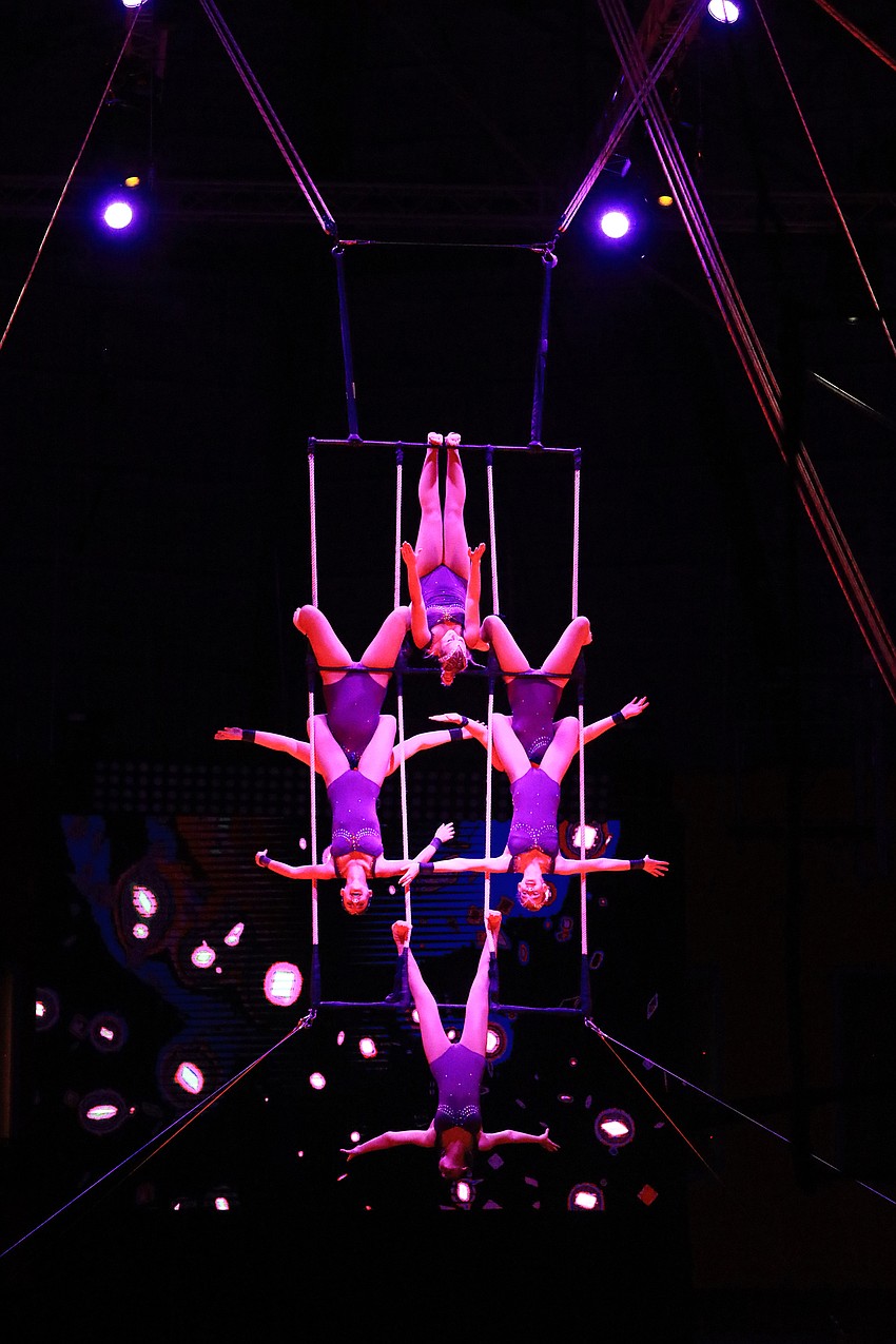 The triple trapeze artists pose together.