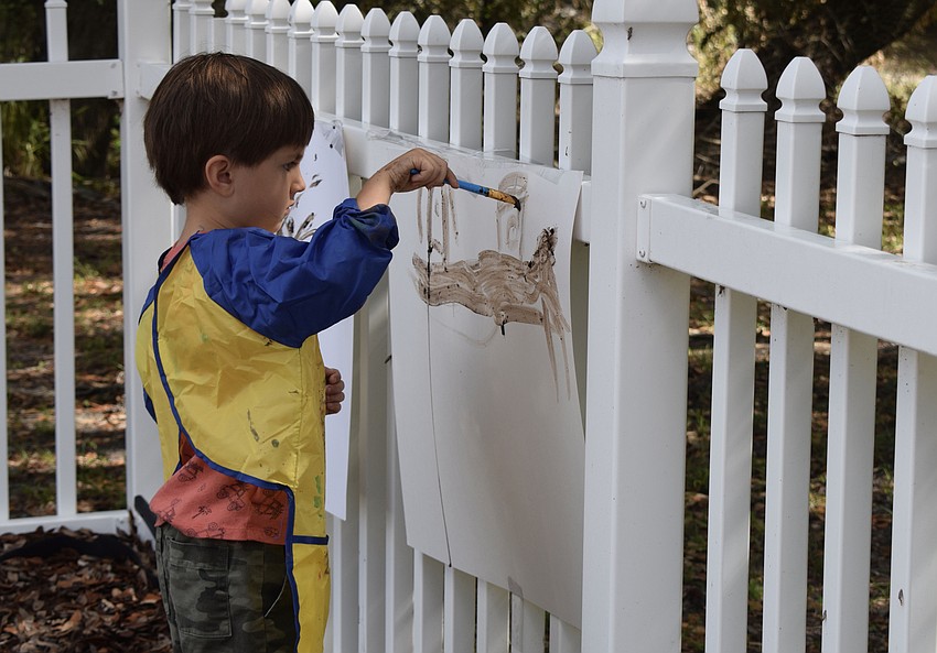 Mote Ranch's Liam Bryne, a World of Wonder Academy student, paints a police station using mud.