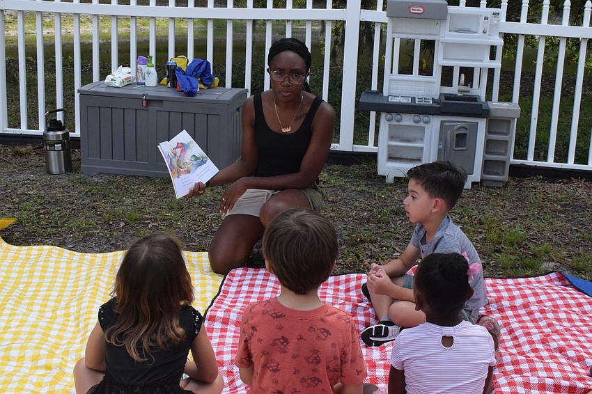 Kiajia Claxton, a World of Wonder Academy leader, reads to students before they move onto other activities.