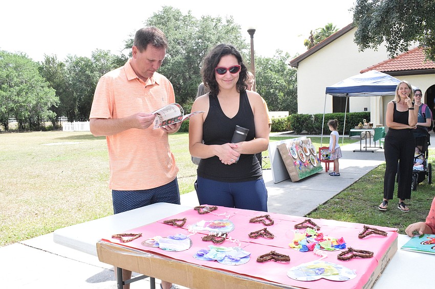 East County's Craig Fisher and his wife, Shannon Keever, admire the artwork from their daughter, Hope Fisher, and other World of Wonder Academy students. 