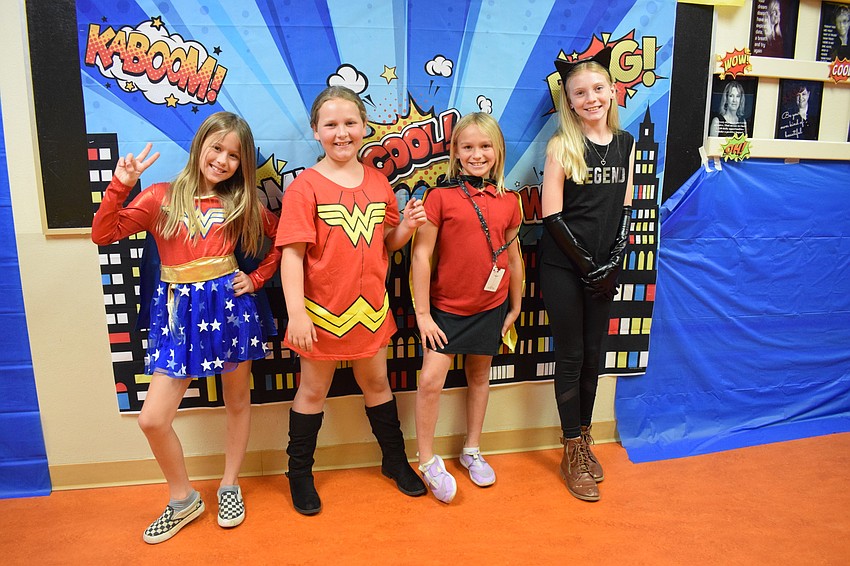 Fourth graders Milia Copeland, Lillian Ploger, Riley Buttery and Ava Sues bring D.C. comics characters to Braden River Elementary. Copeland says it was weird to see school walls decorated like comic strips.