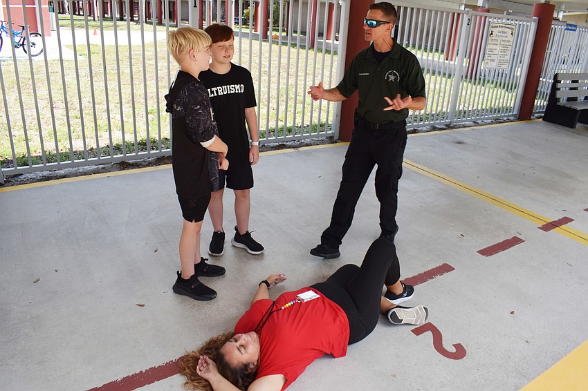 Fifth graders Logan Snyder and Ryland Neary talk to Deputy Tom Kaczmark about what to do if they see someone, like substitute teacher Ana Perreira, injured during an incident.