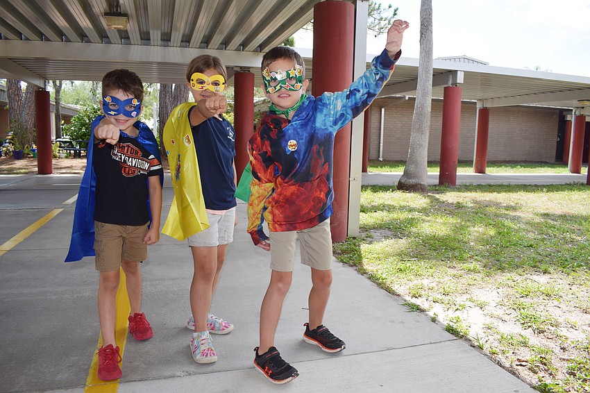 First graders Kingston Miller, Reghen Miller and Tomas Norwood strike a superhero pose.