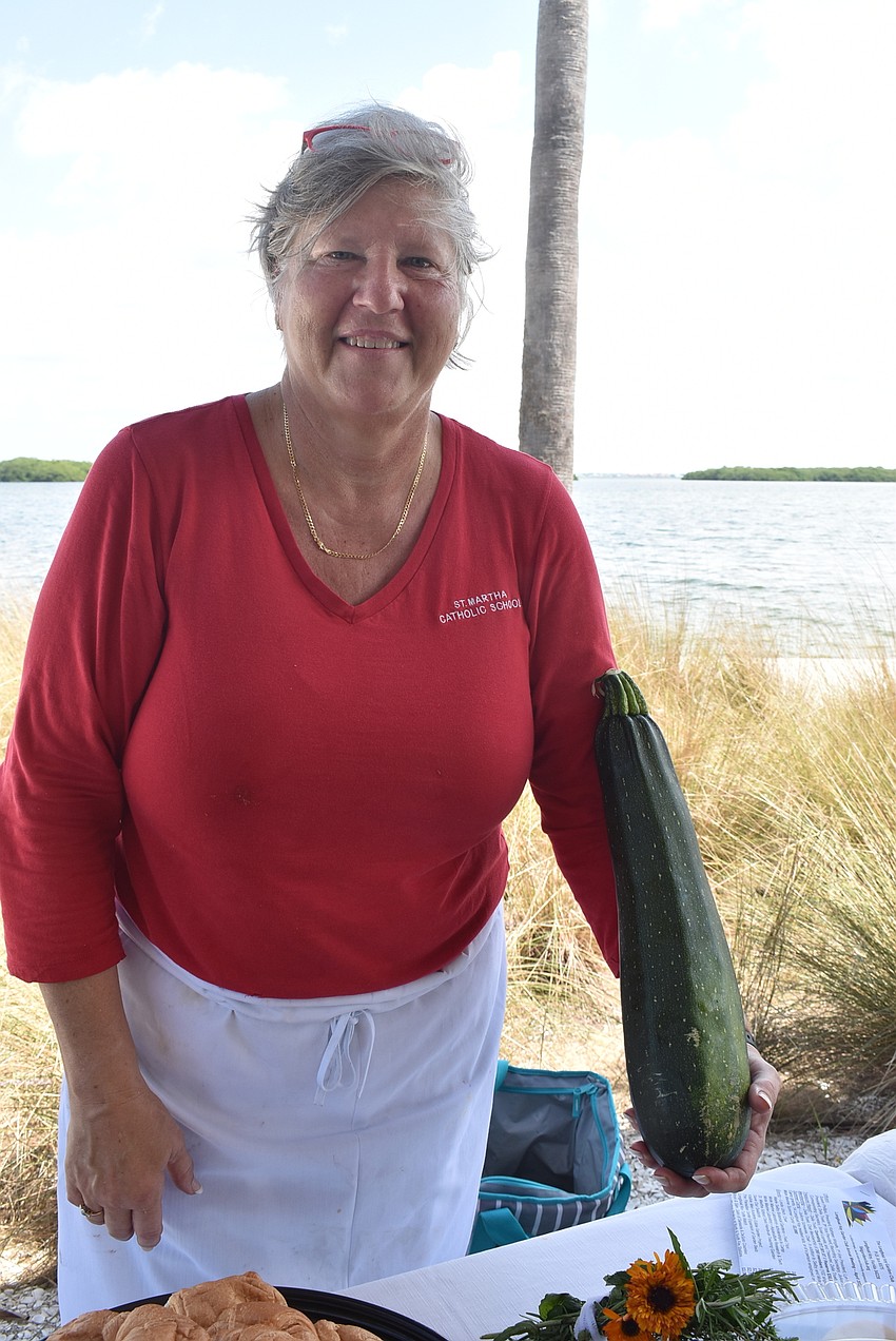 Jean Caldwell shows an oversized zucchini from the St. Martha garden.
