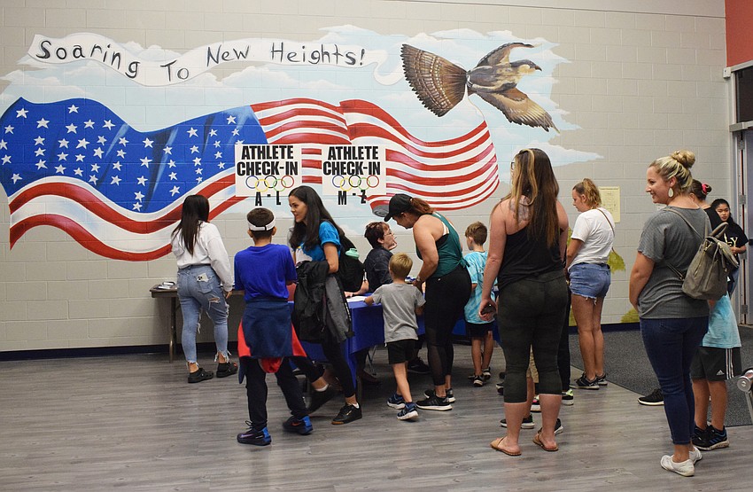 Mother and son Olympians check in before the games begin.