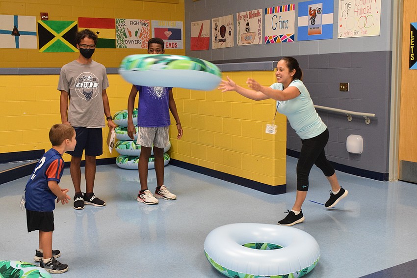 Taylor Puckett, who is in pre-kindergarten, tries to move his body so the ring his mother, Kerlyn Puckett, tossed at him lands on him.