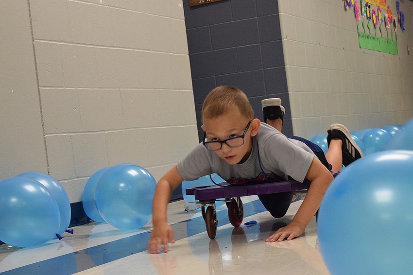 Corum Wikstrom, who is in pre-kindergarten, dashes through a sea of blue balloons in the 