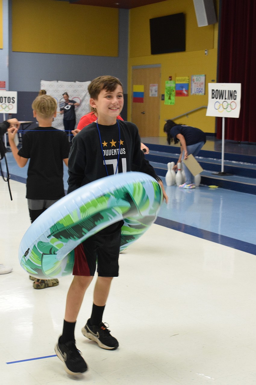 Clayton Upshaw, a fourth grader, celebrates after his mother, Ashley Upshaw, was able to successfully toss a ring onto him.