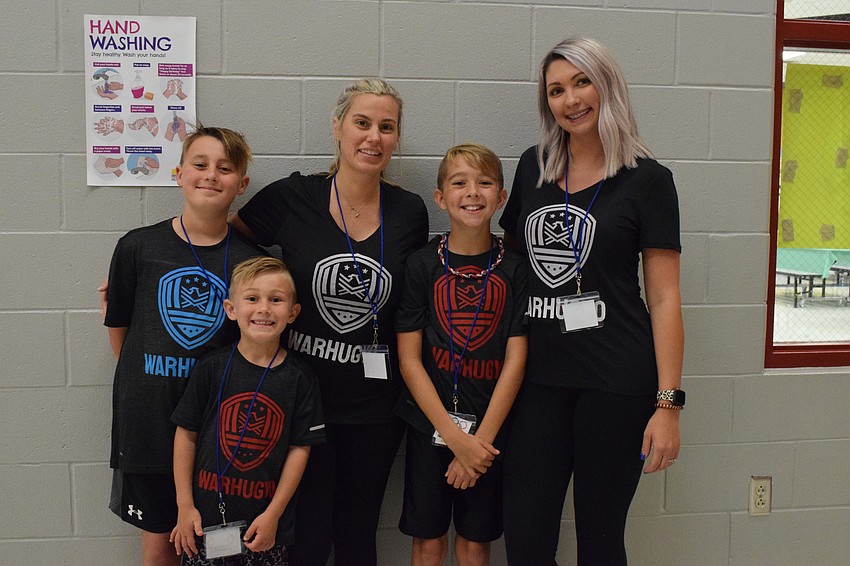 Fifth grader Cooper Young, first grader Tallen Huguet, Jennifer Warren, fourth grader Liam O'Neal and Kara Huguet decide to wear matching shirts during the Olympics.