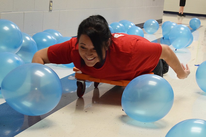 Krista Aloy makes her way through dozens of balloons during a swimming relay with her son Dominick Aloy. 