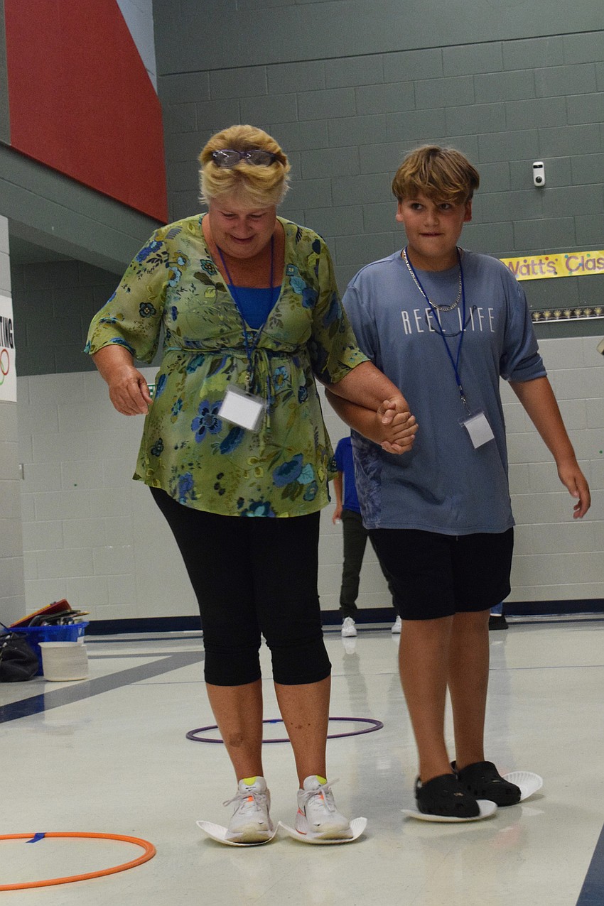Christie Hagar and fifth grader Kellen Hagar try to figure skate their way around hoola hoops as fast as possible. Kellen Hagar says soccer is his favorite event of the night because he likes dribbling through the cones.