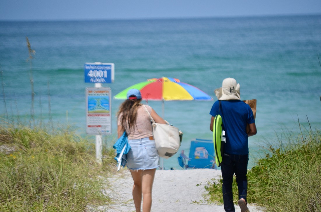 Beachgoers head to the shore in Longboat Key.