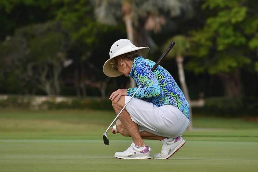 Eileen Murphy squats to measure her putt.