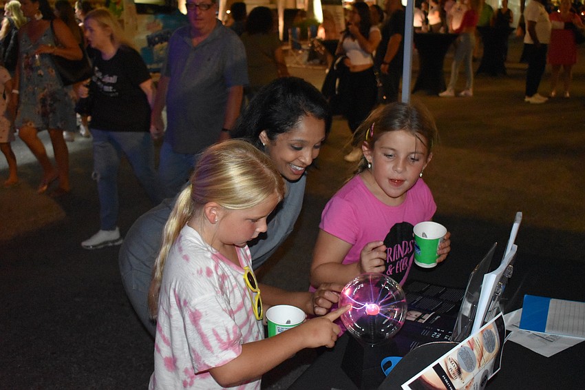 Sophia Chueka, 8, and her cousin Kylie Jordan, 8, learn about plasma globes from Anita Kunwar (center), who provides Opus Plasma skin rejuvenation at East County Internal Medicine.