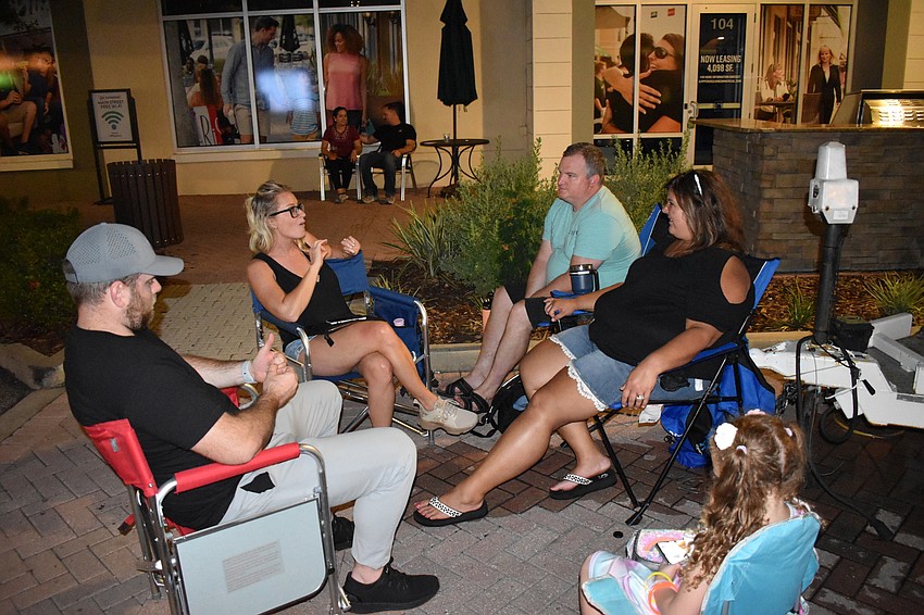 Sean and Michelle Mills of Greyhawk Landing Hammock, and Jeff, Jenny, and Addison Sheu of Woodleaf Hammock, socialize not far from the music stage.
