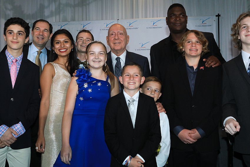 Children and families join Dick Vitale in a photo.